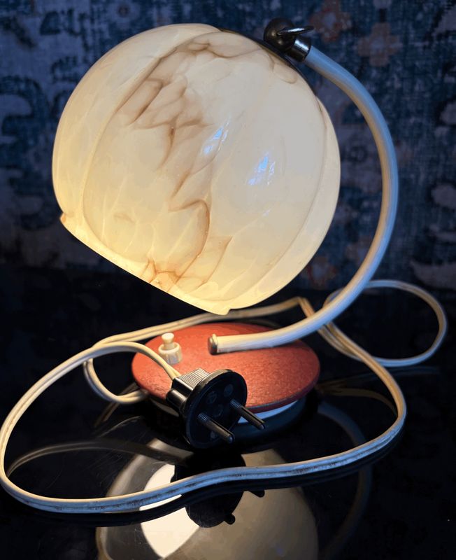 Tafellamp met bolle kap van marmerlook glas op een gebogen chromen voet