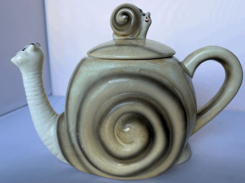 De theepot van de andere kant, met de spiraal van het slakkenhuis en het slakje op het deksel
