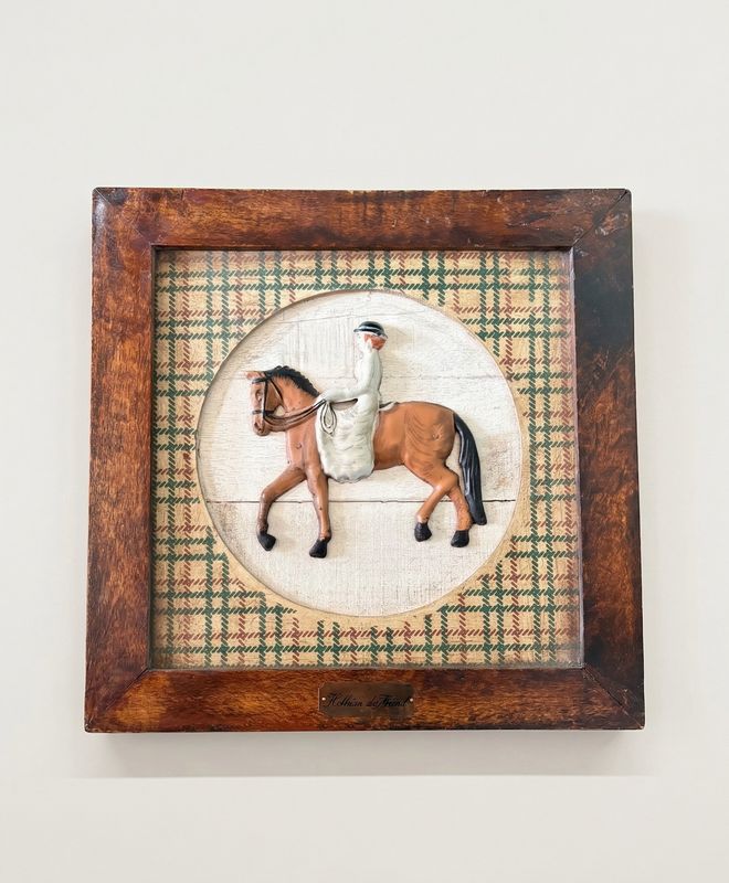 Wandrelief van een ruiter te paard in een houten lijst, op geruite stof