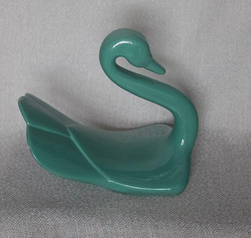Keramieken zwaan met elegante S‑vormige hals, turquoise glans en minimalistisch design.