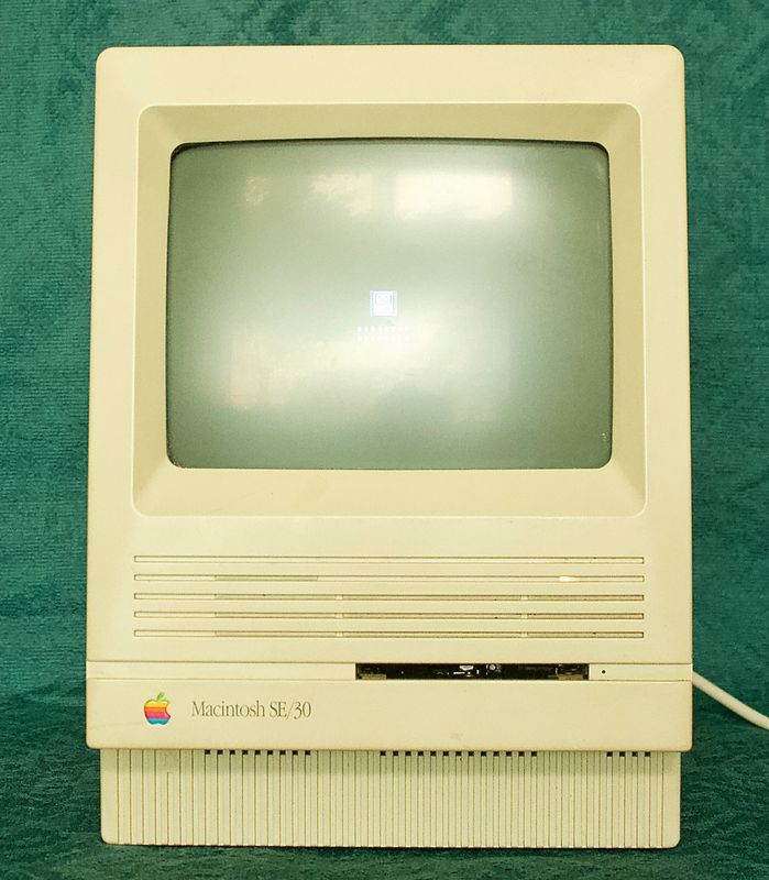 Ingeschakelde Apple Macintosh SE/30 met Sad Mac error icoon op het ingebouwde CRT scherm.