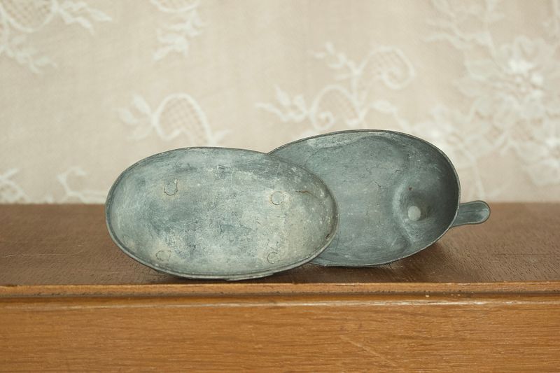 Enkele geopende tinnen eend doos met afneembare rug als deksel en vakje voor sieraden.