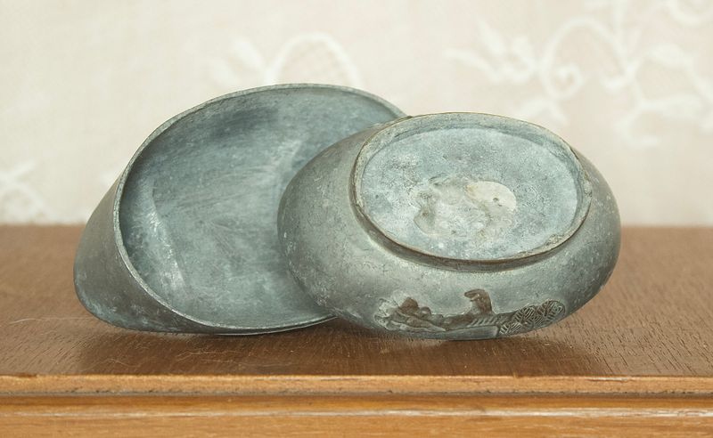 Enkele geopende tinnen eend doos met afneembare rug als deksel en vakje voor sieraden.