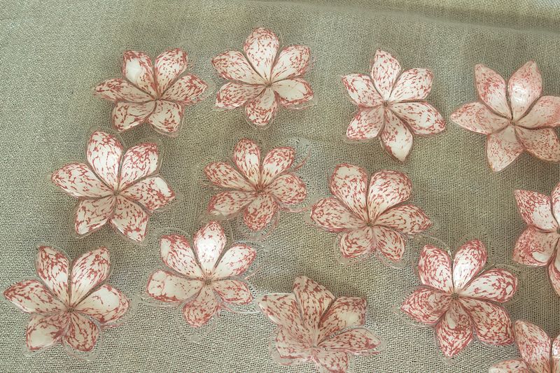 ovenaanzicht van een groep individuele handgeblazen Murano-glazen bloemen op het frame, toont de bloemvormen.⁠