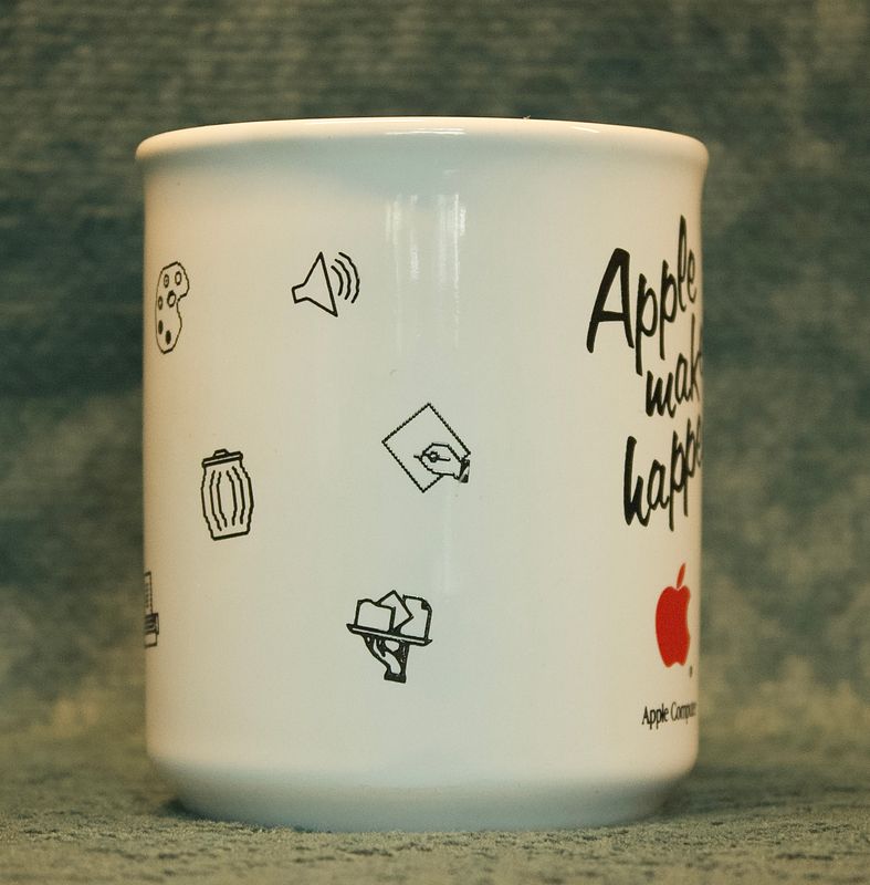Zijaanzicht van de vintage Apple-mok, met iconen van een speaker, een document met een hand, een hand met documenten 