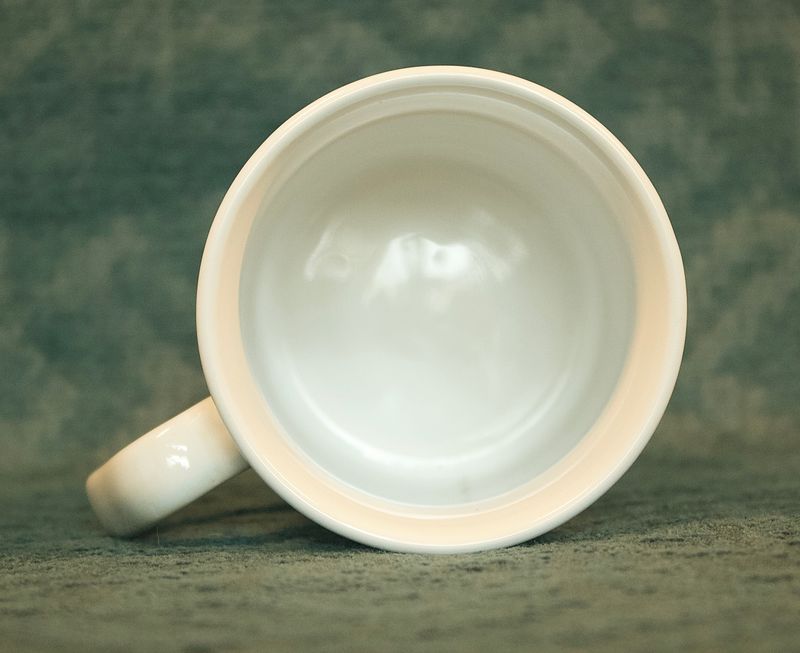 Bovenaanzicht van de vintage Apple-mok, die de holle, witte binnenkant van de mok laat zien.