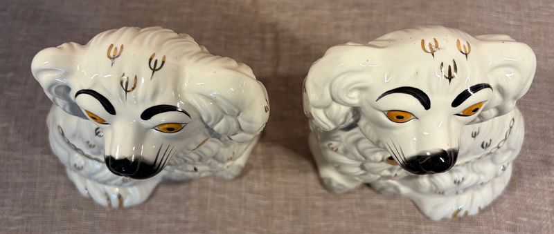 Twee witte porseleinen spanielkoppen naast elkaar, met gouden accenten