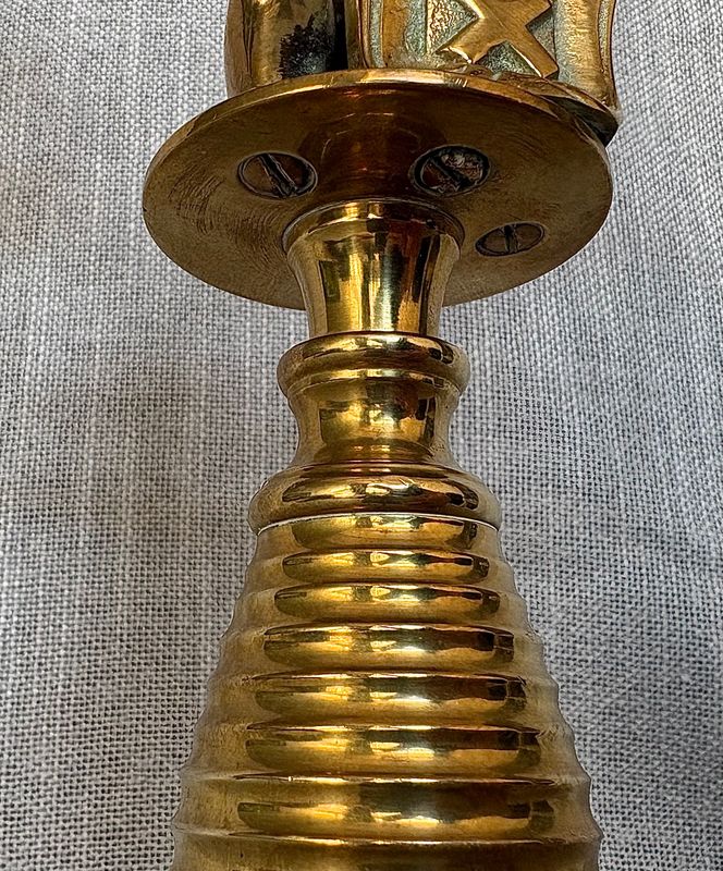 Detailopname van de onderzijde van het middenstuk met de klassieke gleufschroefverbindingen en de geribbelde voet.
