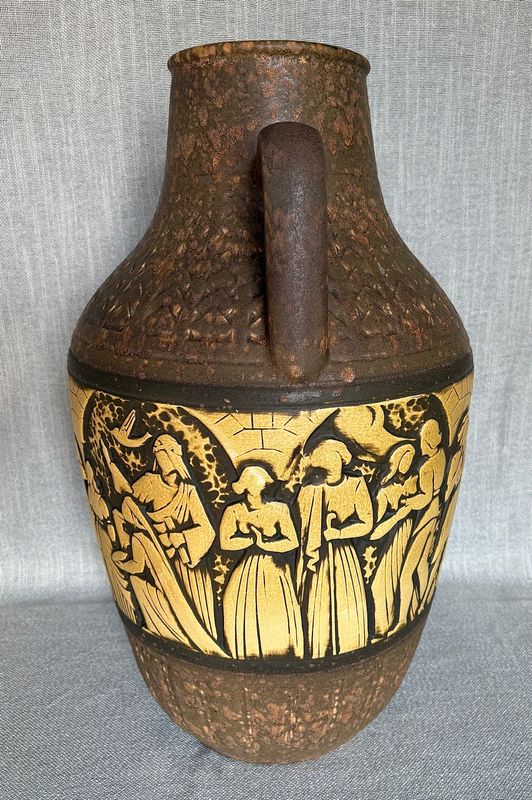 Detailopname van de reliëfband met dansende figuren in klederdracht.