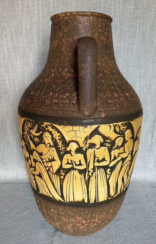 Detail van de reliëfband met wandelende figuren in klederdracht.