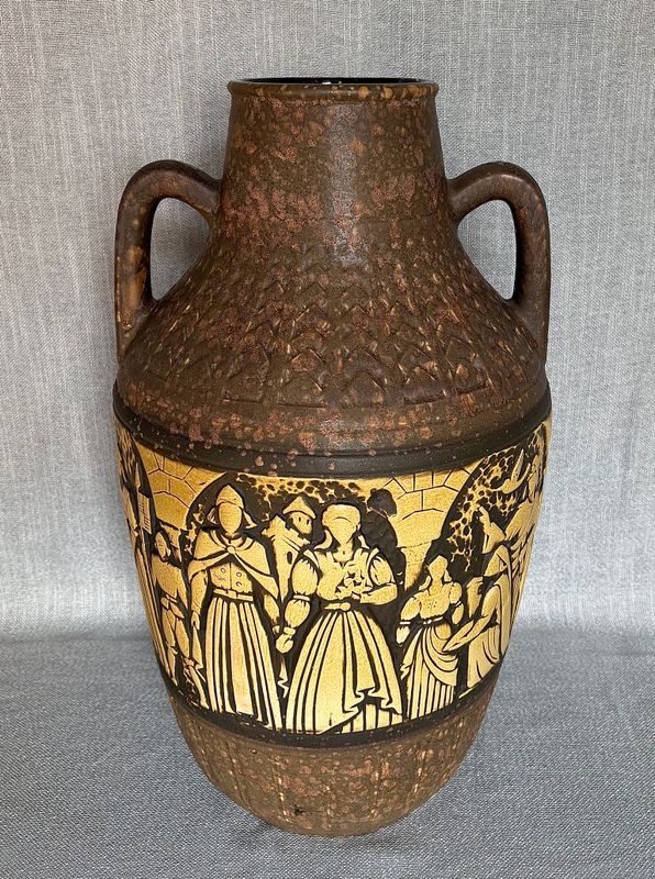 Detail van de reliëfband met figuren bij een middeleeuws gebouw.