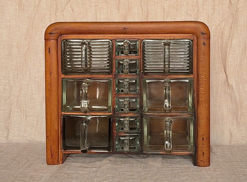 Compleet art deco kruidenrek met 12 originele glazen bakken, waaronder Cubex en Poncet. Massief houten kastje, jaren 30.