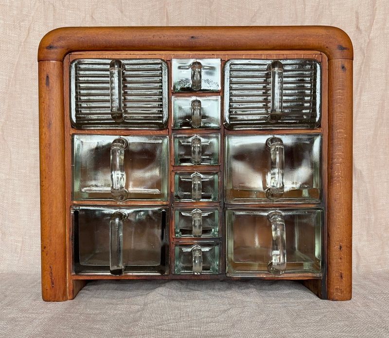 Vintage houten kruidenkastje met 6 grote en 6 kleine glazen lades met uitstekende glazen handgrepen.