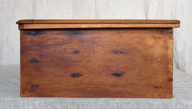 Detailopname van het houten oppervlak aan de zijkant van de kast met een lichte patina.