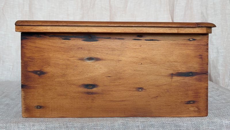 Detailfoto van de houten zijkant van de kast met natuurlijke verkleuringen in het hout.