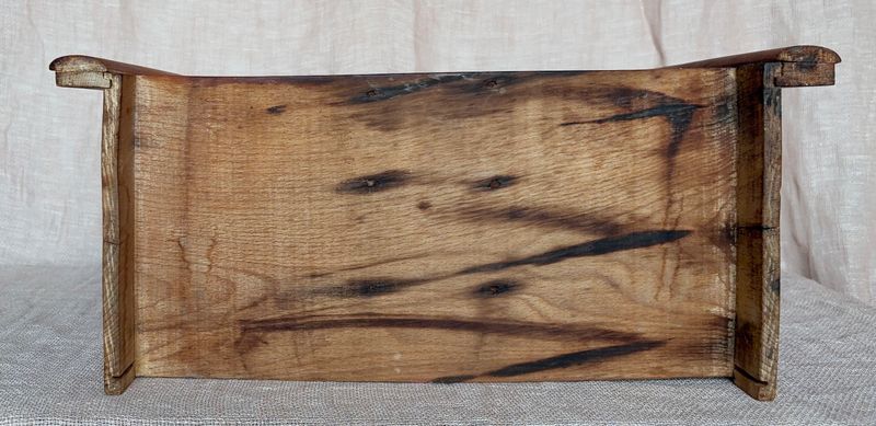 Detail van de houten onderkant, met een duidelijke, donkere houtnerf.