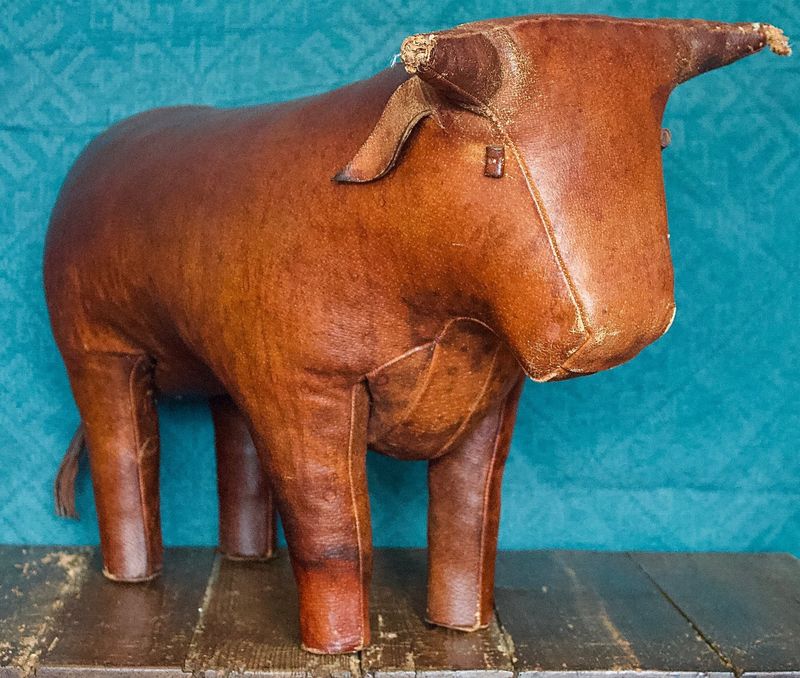 Stier van bruin leer met zichtbare naden, op een houten plank