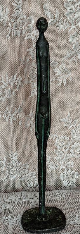 Staande figuur in stijl van Giacometti, beschadiging buik
