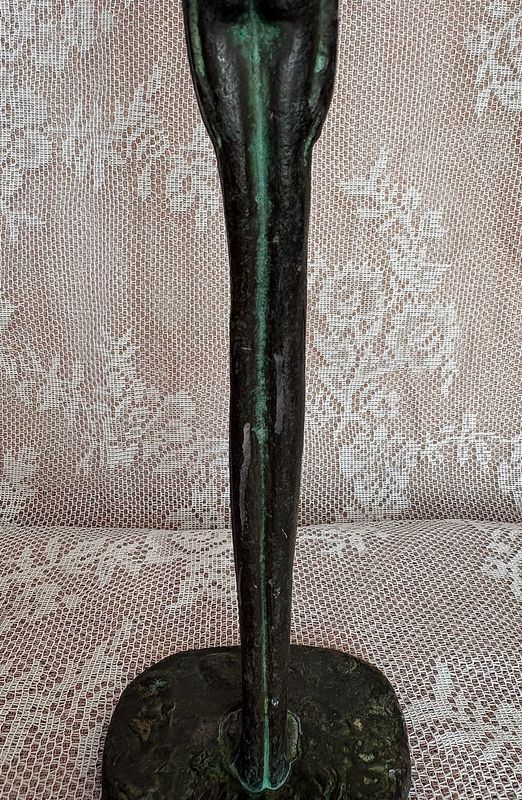 Staande figuur in stijl van Giacometti, schaafplekken op de achterzijde van de benen