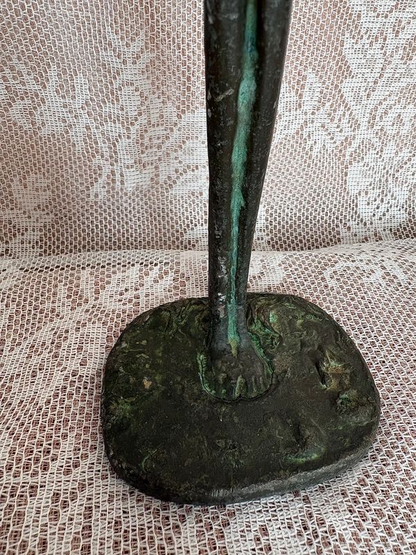 Staande figuur in stijl van Giacometti, naad rond de voet in de voetplaat