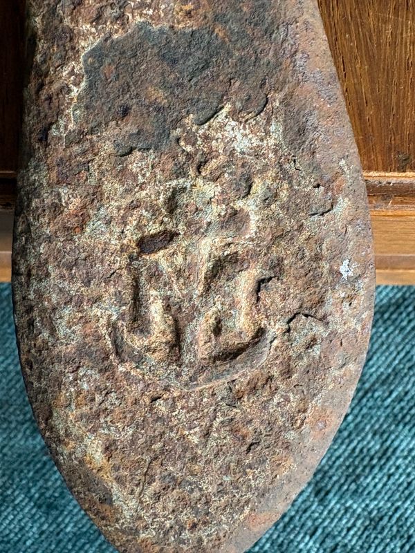 Close-up van het geroeste anker met het gietmerk in relief