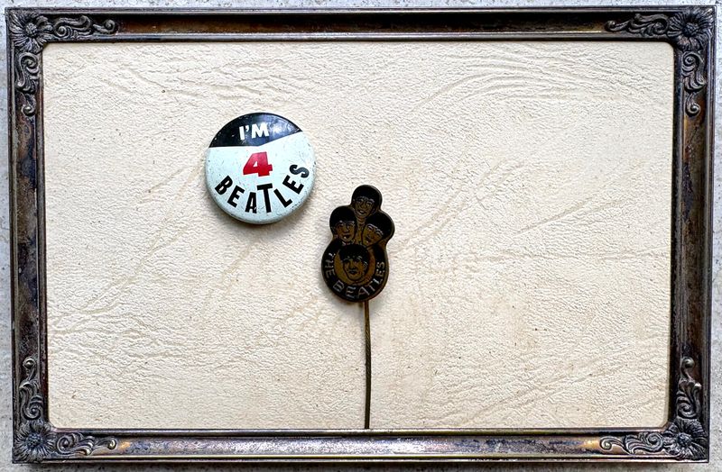 Beatles button en speldje op cremekleurig leer in een zilverkleurige lijst